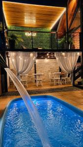 a swimming pool with a water fountain at Chalé 17 I Conforto e Lazer na Serra I Gravatá PE in Gravatá