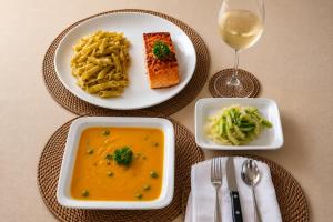 a table with two plates of food and a glass of wine at Entre Bosques Tayrona in Los Naranjos