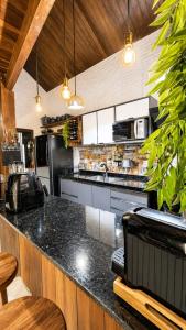 a kitchen with a black counter top in a room at Chalé 17 I Conforto e Lazer na Serra I Gravatá PE in Gravatá