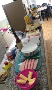 a counter with a tray of food and a plate of food at Pousada Central Itabirito in Itabirito