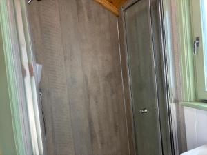 a bathroom with a wooden door in a room at Sea Farm Stays in Broadstairs