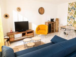 a living room with a blue couch and a tv at maison cosy centre ville in Ham
