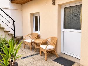 a patio with two chairs and a table and a door at maison cosy centre ville in Ham