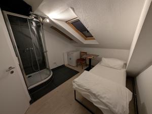 a small bedroom with a shower and a bed at Mainrooms Kelsterbach in Kelsterbach