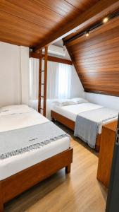 two beds in a room with wooden ceilings at Chalé 17 I Conforto e Lazer na Serra I Gravatá PE in Gravatá +23 photos