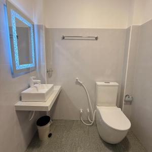 a white bathroom with a toilet and a sink at Yalora Villa Kataragama in Kataragama