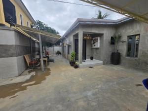 a patio of a house with water on the ground at Virginhomes apartment in Jibowu