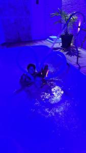 two children swimming in a pool in a dark room at Caueira Beach House in Itaporanga dʼAjuda