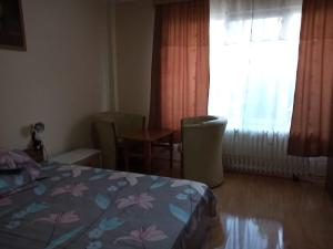 a bedroom with a bed and a table and a window at Vila Angeli in Techirghiol +5 photos