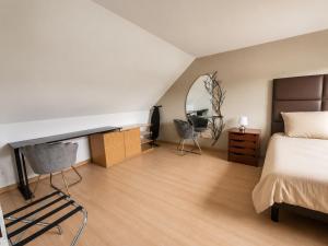 a bedroom with a bed and a desk and a mirror at La Clef des vignes 4 in Roye