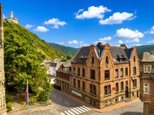 an old building with a mountain in the background at Zum Rheinberg Balcony Suite in Braubach