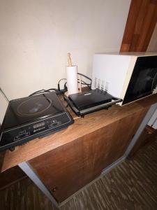 a microwave and a printer on a wooden table at Departamento Monoambiente Rústico in Asunción