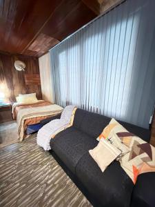 a living room with a couch and two beds at Departamento Monoambiente Rústico in Asunción