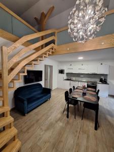 a living room with a dining table and a staircase at Apartmány Aktiv Lipno in Lipno nad Vltavou