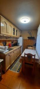 a kitchen with a table and a white refrigerator at Casa Răzvan in Arieşeni