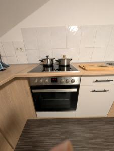 a kitchen with two pots on top of a stove at Mainrooms Kelsterbach in Kelsterbach