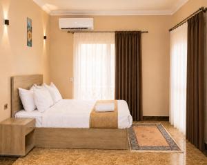 a bedroom with a bed and a large window at Roadhouse New Cairo Residence in Cairo