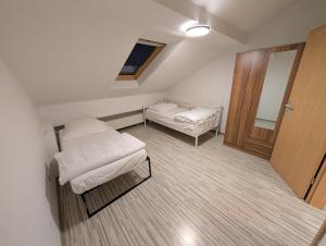 a small room with two beds and a door at Mainrooms Kelsterbach in Kelsterbach