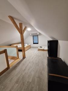 an attic room with two beds and a tv at Apartmány Aktiv Lipno in Lipno nad Vltavou