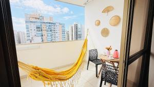 a hammock in a room with a view of a city at Praia Dourada in Vila Velha