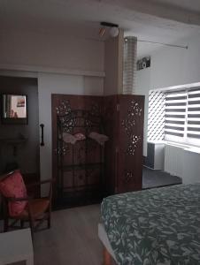 a bedroom with a bed and a door and a chair at Maison Belzaenea in Espelette