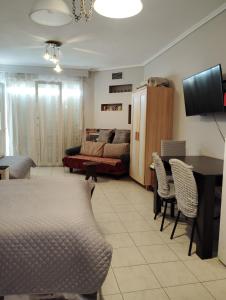 a living room with a couch and a table and chairs at Roses Apartments in Nea Michaniona