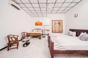 a bedroom with two beds and a table and chairs at Dudley Nature Resort in Habarana
