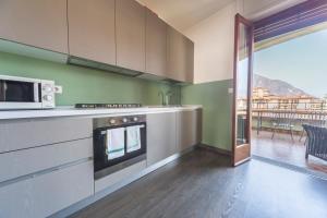 a kitchen with a stove and a microwave at Villa Senagra Holidays Lake Como in Menaggio