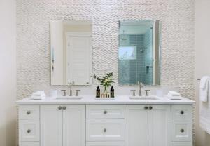 a white bathroom with two sinks and a mirror at Moringa Villa in Long Bay Hills