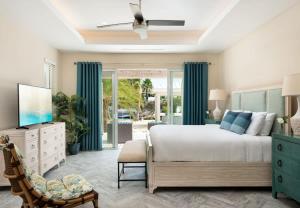 a bedroom with a large bed with blue curtains at Moringa Villa in Long Bay Hills +26 photos