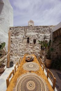 a wooden table and chairs in front of a stone wall at Casa Moro in Episkopi 16km from Rethymno in episkopi-chania +45 photos