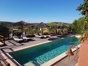 a pool with chairs and umbrellas on a patio at Gato Preto de Silves - Adults Only in Silves