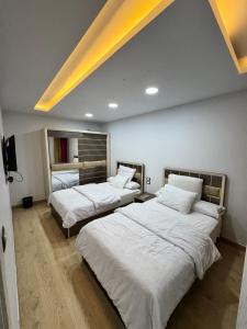 a room with three beds with white sheets at Helnan portfouad chalet in Chantier Island +10 photos