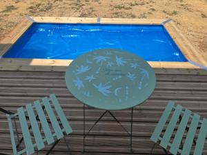 ein Tisch und zwei Stühle vor einem Pool in der Unterkunft L' Ecrin in Auch