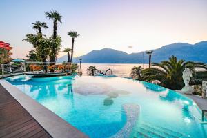 a large swimming pool next to a body of water at Belfiore Park Hotel 4Stars Superior "Adults Only" in Brenzone sul Garda