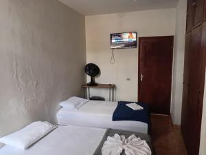 a hotel room with two beds and a television at Pousada Central Itabirito in Itabirito +7 photos
