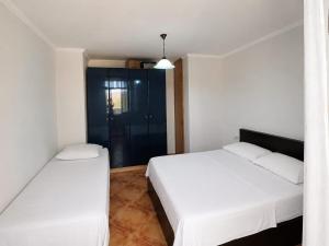 a bedroom with two beds and a glass door at APP Apartament in Durrës