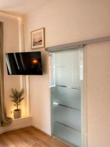 a glass refrigerator in a room with a tv on the wall at Gasthof Schausten in Kreuztal