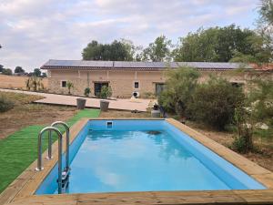 ein großer blauer Swimmingpool vor einem Haus in der Unterkunft Chicken Fields Good ! in Auch