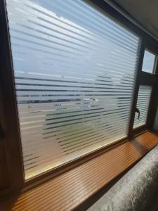 a window with a view of a beach through it at The Rose in Grays Thurrock