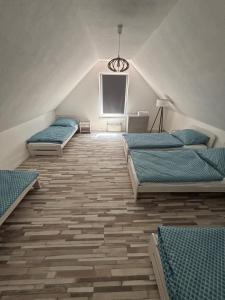 a attic bedroom with three beds and a chandelier at Chata pod hradom in Divín