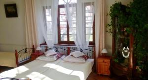 a bedroom with a bed with white sheets and pillows at Stary Dwór in Szczawnica