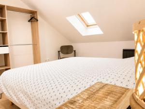 a bedroom with a bed and a skylight at Bel appartement 2 chambres in Ham