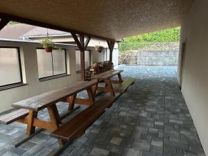 two picnic benches on a patio with a wall at Chata pod hradom in Divín