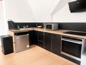 a kitchen with a sink and a microwave at Bel appartement 2 chambres in Ham +6 photos