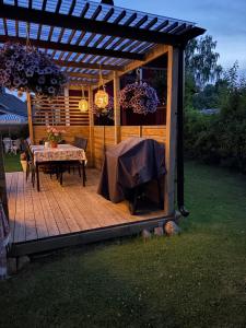a wooden deck with a table and a pergola at Villa Tornhaga in Oskarström +22 photos