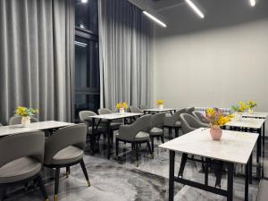 a dining room with tables and chairs and curtains at Wind Rose in Almaty