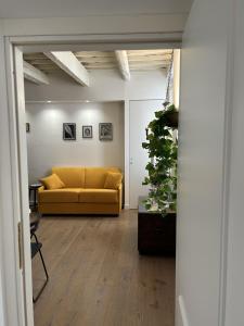 a living room with a yellow couch and a plant at Ver Sacrum - Appartamento in centro in Ascoli Piceno