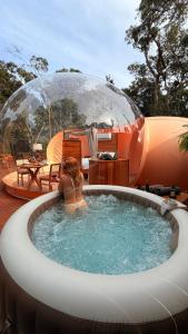 a woman sitting in a hot tub in a dome at Sora Bubble in Angelina +16 photos