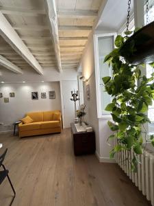 a living room with a yellow couch and a plant at Ver Sacrum - Appartamento in centro in Ascoli Piceno